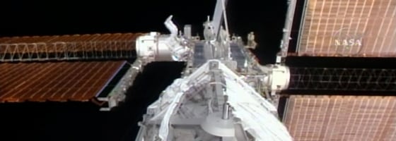 Swedish astronaut Christer Fuglesang, seen with his feet sticking up, works on the international space station during Tuesday's spacewalk. Fuglesang and crewmate Bob Curbeam installed a new segment on the station.