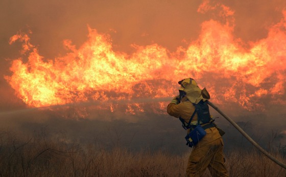 A firefighter works the Esperanza Fire near Cabazon, Calif., Thursday, Oct. 26, 2006. Drought and hot conditions contributed to a record wildfire season, with more than 9.5 million acres burned through early December.