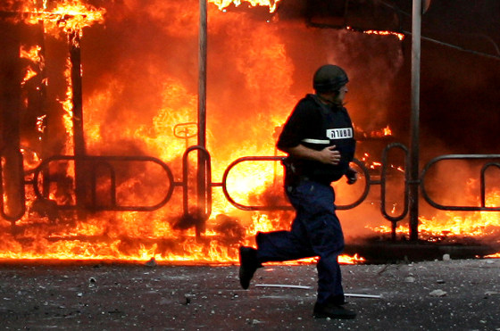 An Israeli police officer runs to the site where a Hezbollah-fired rocket directly hit a building in the northern costal town of Nahariya on July 13, during the war between Israel and Hezbollah. 