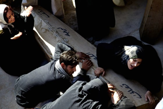 Iraqis mourn over the coffin of their re