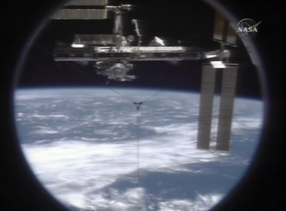 The international space station floats above the blue and white of Earth in an image captured by a camera on the space shuttle Discovery just after Tuesday's undocking.