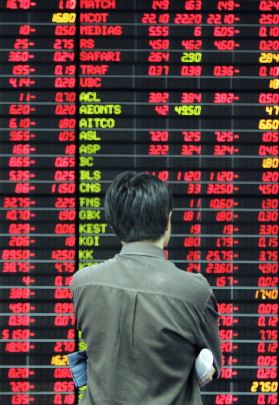 An investor monitors an electronic board at a private trading floor in Bangkok, Thailand, Tuesday, where stocks plummeted nearly 15 percent, a record, after the central bank announced rules to discourage foreign capital inflows.