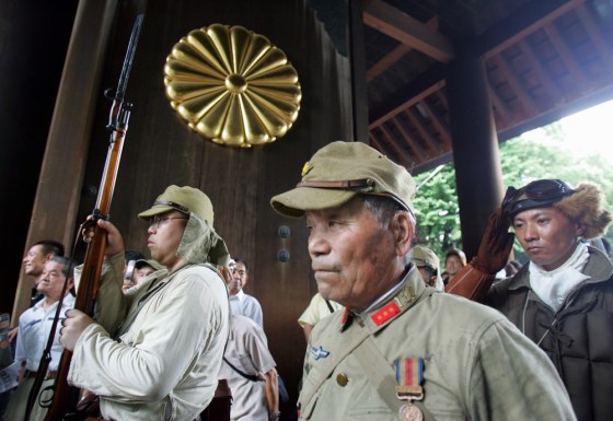 Japanese men in military costumes pay respects to the nation's war dead at the Yasukuni Shrine in Tokyo on Aug. 15, 2006.