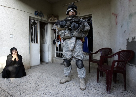 A U.S. Army soldier from Company B of the 5th Batallion, 20th Infantry Regiment, stands guard as other soldiers search a home for weapons and suspected insurgents in Baghdad on Monday.
