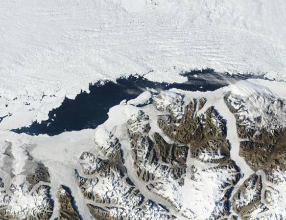 This NASA satellite image shows the Ayles Ice Shelf collapse, center and below the open water, on Aug. 13, 2005. Within days of breaking free and becoming an island, Ayles drifted about 30 miles before freezing into the sea ice seen here along top of photo.