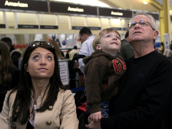Robin Wexler, right, an anxious flyer, waits in line at American Airline ticket counter at National airport with his family as they prepare to board flight for a vacation in Mexico. Robin holds his grandson Eli, 2. Robin's daughter, Emily Holden, is at left.