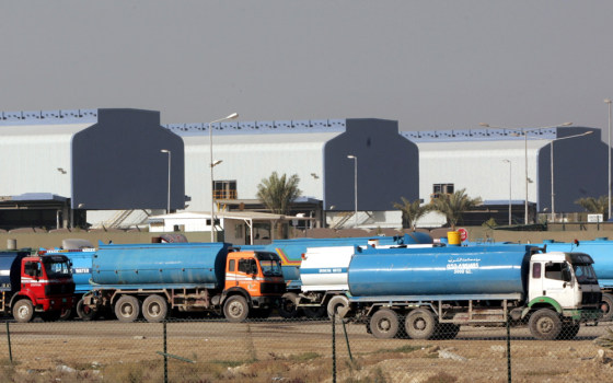 Trucks drive in front of an aluminum smelting plant to fill up with fresh water distilled from gulf seawater in Dubai, United Arab Emirates. Residents of the small desert isle outpace Americans in terms of energy consumption, says the World Wildlife Fund.
