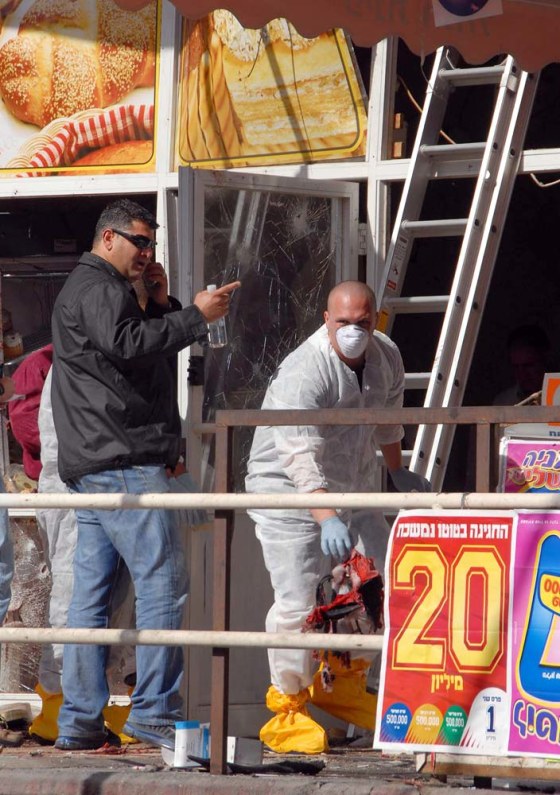 A forensic officer inspects the scene of Monday's suicide bombing in the southern Israeli city of Eilat.