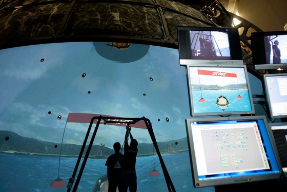 Software developers demonstrate the Computer Assisted Rehabilitation Environment simulator, designed to help patients use atrophied muscles and relearn skills necessary in daily life, at the Center for the Intrepid in San Antonio, Texas, over the weekend.