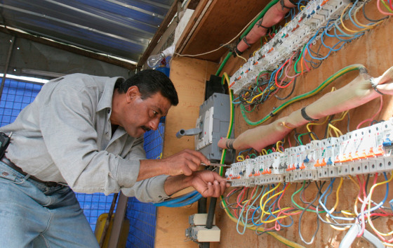 An employee of a private generator company, which supplies electricity to most Baghdad residents, works on circuit breakers in Baghdad, in March 2006. The new audit shows electrical output still averages below pre-war levels.