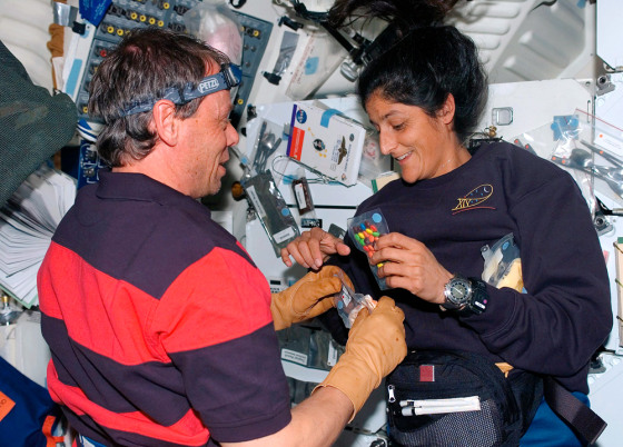 European Space Agency astronaut Christer Fuglesang of Sweden and Sunita Williams, both STS-116 mission specialists, enjoy light moment on middeck of space shuttle Discovery