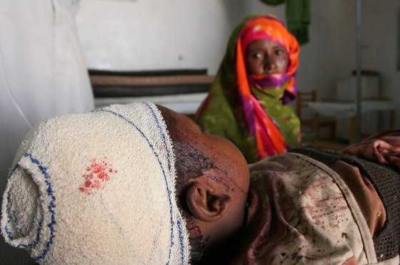 A woman sits beside her injured son inside the hospital in Adre bordering Sudans Darfur region