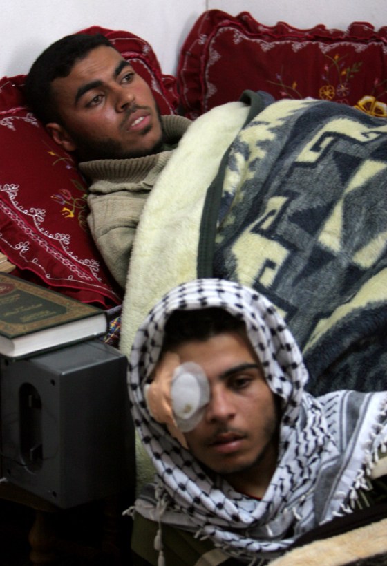 Palestinian Hamada al-Ottol, 19, below, and his brother Tahseen, 22, gather together in one room of their family house for the media, in the Jabaliya refugee camp, northern Gaza Strip, on Tuesday. The brothers, who fought on opposing sides, were both badly wounded in a recent clash between Hamas and Fatah. 