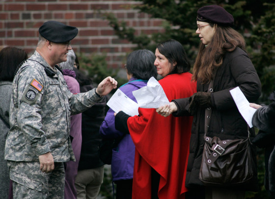 A military policeman checks for clearance letters from people waiting in line to observe the second day of 1st Lt. Ehren Watada's court-martial Tuesday at Fort Lewis, Wash.