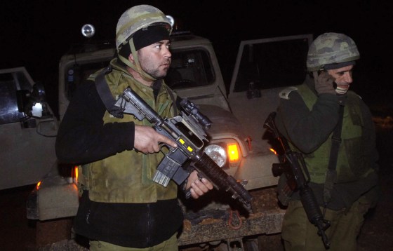 Israeli soldiers take positions along the Israeli-Lebanese fence near the Israeli border village of Avivim, on Thursday after troops exchanged fire late Wednesday. 