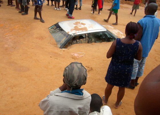 Residents of Luanda crowd around cars buried under mud after days of torential rains