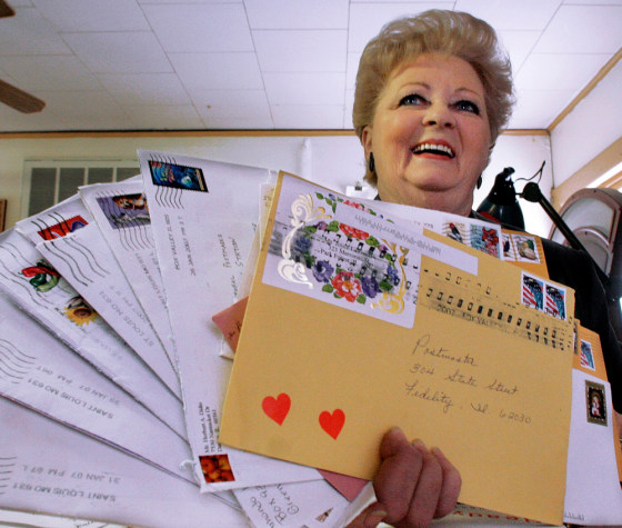 Postmaster Peggy Ruyle displays a handful of mailings sent her way from around the globe for postmarking in advance of Valentine's Day in Fidelity, Ill. 