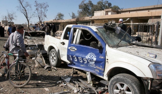 A boy looks at a police vehicle destroyed in a suicide bomb attack near Dour near Tikrit
