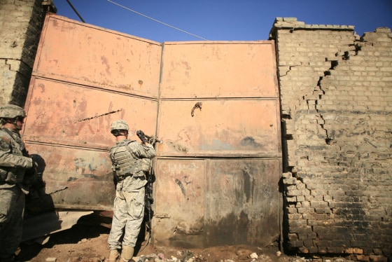 A soldier forces his way into an auto repair lot in Baghdad, Iraq, on Sunday. U.S. troops in the midst of a security crackdown are urging Iraqis to help them get to the root of the city's violence.