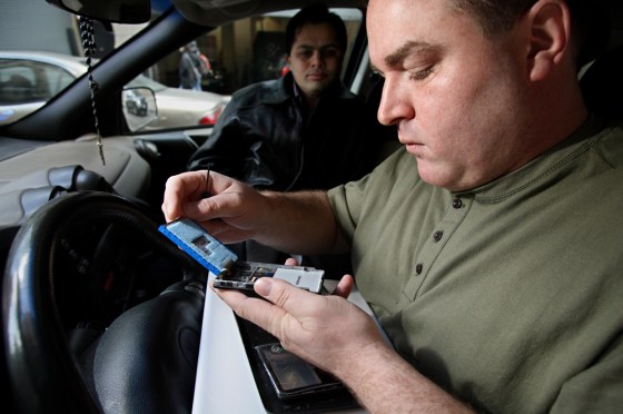 Demetrios Leontaris fixes iPods in the front seat of his SUV often as the owner looks on.