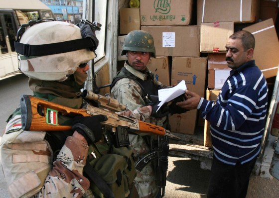 Iraqi soldiers check boxes inside a truck at a checkpoint in Baghdad