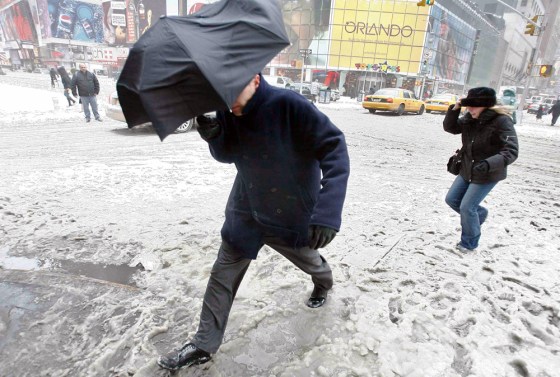 Pedestrians walk way through Times Square during a snow in New York