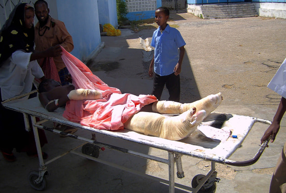 A wounded Somali youth is wheeled away o