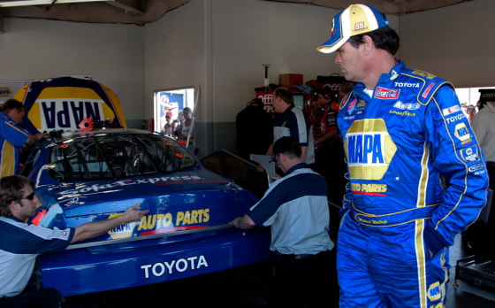 NASCAR driver Michael Waltrip, right, watches as his crew works on his Toyota during practice earlier this week. Waltrip’s cheating scandal has dented the automaker’s Daytona debut.