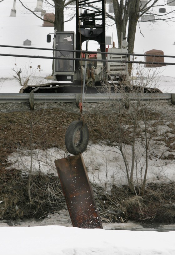 A crane drops a weight into the Winooski River to break up ice jams in Montpelier, Vt., on Tuesday.
