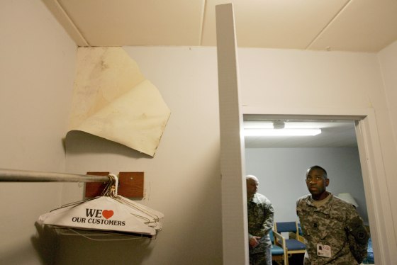 Army Master Sgt. Gary Rhett, building manager, looks last Thursday at a section of wallpaper that was pulled back to reveal mold in a room in the Walter Reed Army Medical Center, which was used to house recovering wounded soldiers. 