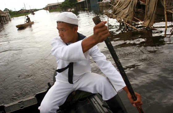 A Bolivian sailor uses an inflatable boat to help people reach their flooded homes in the northwest city of Trinidad, Bolivia, on March 5.