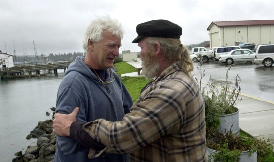Dave Sharp, right, talks with Don Yost, who quit his job as harbormaster rather than impound the boats of salmon fishermen who have fallen months behind in paying their mooring fees, on March 19 in Coos Bay, Ore.