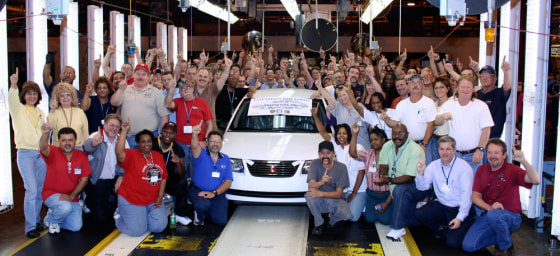 Workers surround the last Saturn Ion sedan that rolled off the line at the Saturn plant in Spring Hill, Tenn.