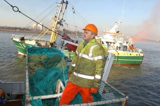 ** ADVANCE FOR SUNDAY, APRIL 1 ** FILE ** A fisherman stands on a basket of nets aboard his ship as a group of North Sea fishing boats pull in to anchor in the Port of Antwerp, Belgium, Dec. 10, 2003. North Sea fisherman gathered in Antwerp to protest proposed EU cuts on commercial catches of cod, hake and other dwindling varieties. Overfishing has cut deeply into the North Sea's cod population in recent decades, and scientists now say this important food fish faces a second challenge _ climate change. (AP Photo/Virginia Mayo)