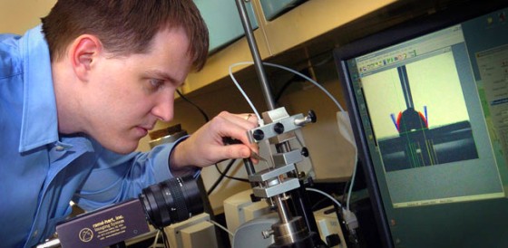 Jeffrey Youngblood, a Purdue assistant professor of materials engineering, works with equipment that enables researchers to measure the "contact angle" of a liquid as it beads up on a surface.
