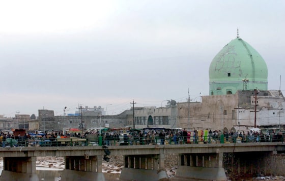 People sell items in an open marketplace on a bridge in downtown Kirkuk, 180 miles north of Baghdad, on Feb. 11. A new policy would pay Arabs who moved to the city after 1968 to leave, making way for Kurds to regain control of the oil-rich area.