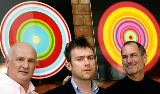 CEO of EMI Group Nicoli and CEO of Apple Jobs pose for photographers with British musician Albarn in London