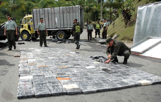 A policeman arranges packs of confiscated cocaine in Medellin