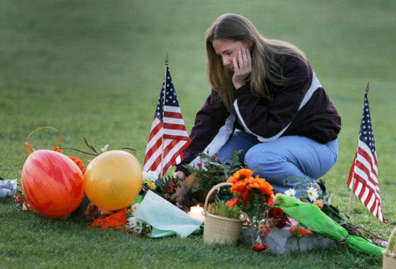Virginia Tech alumnus Michelle Creamer, 25, of Bracey, Va., visits the makeshift memorial in front of Burruss Hall on the campus of Virginia Tech University in Blacksburg, Va., on Saturday.