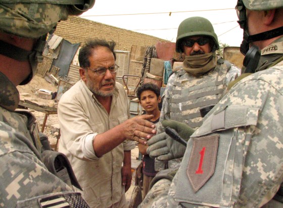 Soldiers of the Army's 2nd Battalion, 16th Infantry Regiment, speak with a a man who lives in a mudbrick hovel that the Army hopes to turn into a combat outpost in Khamaliya, Iraq. At first, the man thought the Army was telling him to leave, but he later thanked the troops for trying to protect him and his family.