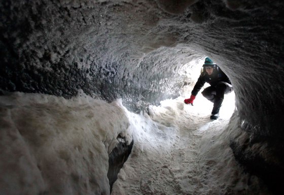 Dutch scientist Appy Sluijs enters a cave at the bottom of the Longyearbyen glacier
