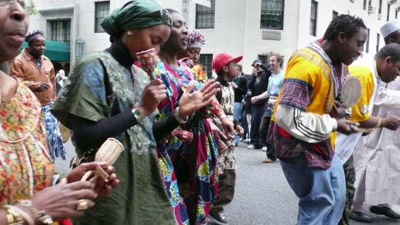 Playing instruments and clad in traditional African dress, "Dance Parade" demonstrators groove their way down New York City streets to call for an end to Prohibition-era laws that forbid dancing everywhere except in those establishments possessing a special license. 