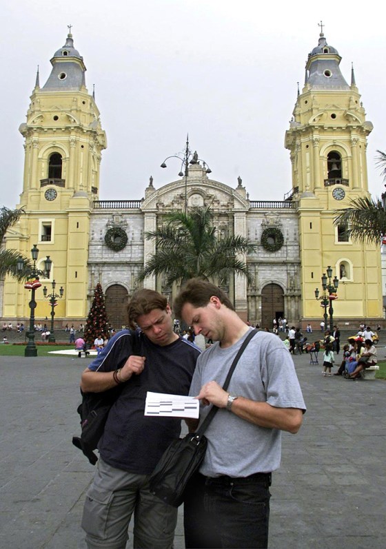 Two tourists read a guide book in the Plaza Mayor