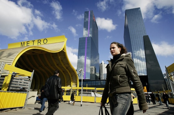 A girl walks in front of the towering office of Nationale Nederlanden in Rotterdam, the Netherlands. On May 14, 1940 a Nazi bombardment flattened buildings and sparked an inferno that destroyed most of downtown Rotterdam, creating an architects' playground during post-World War II reconstruction. 