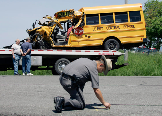 New York State Trooper Jeff Bebak reconstructs an accident scene involving a Le Roy Central School bus and a dump truck in Batavia, N.Y., on Wednesday. The small school bus carrying 14 people collided with a dump truck Wednesday, seriously injuring the driver and two passengers.