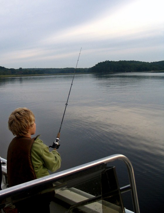 Nathaniel Harpaz, 8, waits for a bite just after sunrise on the Kennebec River in Bath, Maine.