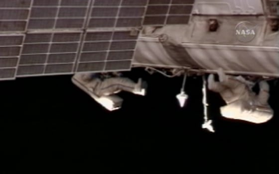 Spacewalkers Fyodor Yurchikhin and Oleg Kotov roll out data cable along the exterior of the international space station on Wednesday.