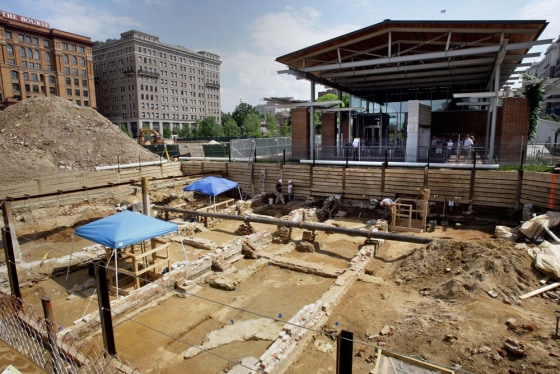 The remains of Colonial-era buildings, including the house that George Washington lived in when he was president, are exposed at an archaeological dig in front of the Liberty Bell Center, top right, in Philadelphia. Archaeologists have discovered a hidden passageway that was used by Washington's nine slaves.