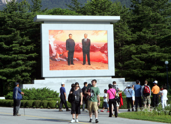 Visitors look at a portrait of North Korea's late leader Kim Il Sung, right, and current leader Kim Jong Il at the Diamond Mountain in North Korea on June 10.