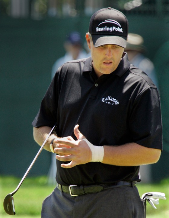 Phil Mickelson, his left wrist taped because of a recent injury, putts on the practice green as he prepares for the 107th U.S. Open.